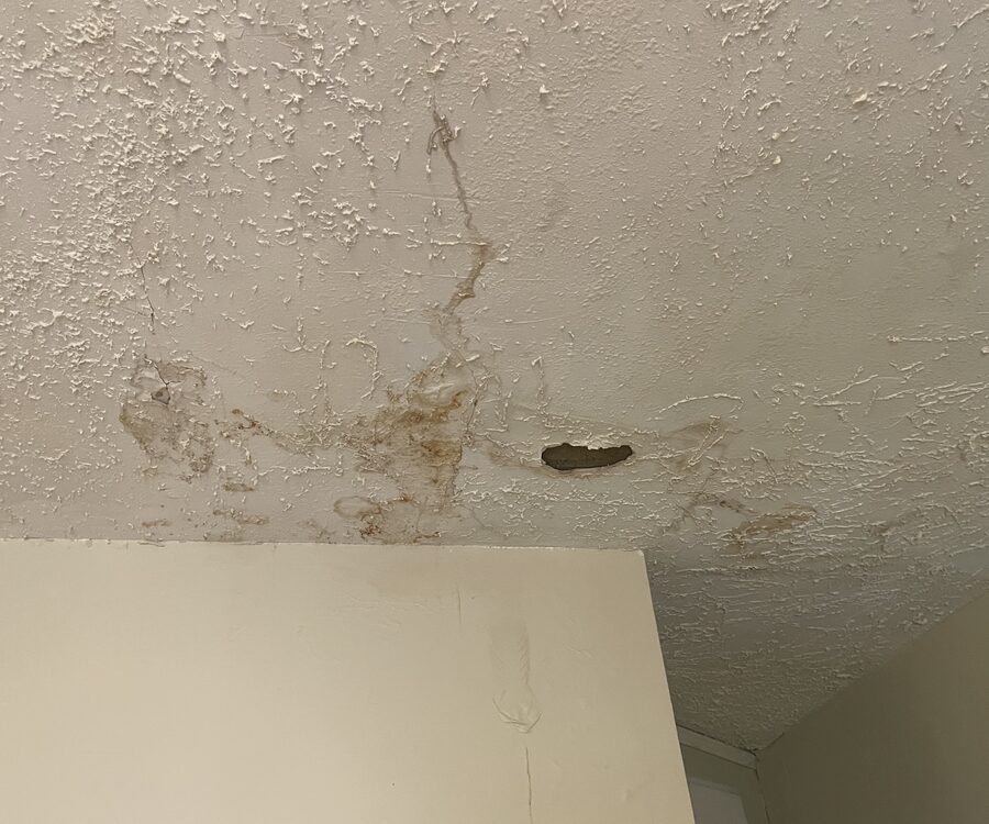 Water staining and cracking on a ceiling documented during an assessment